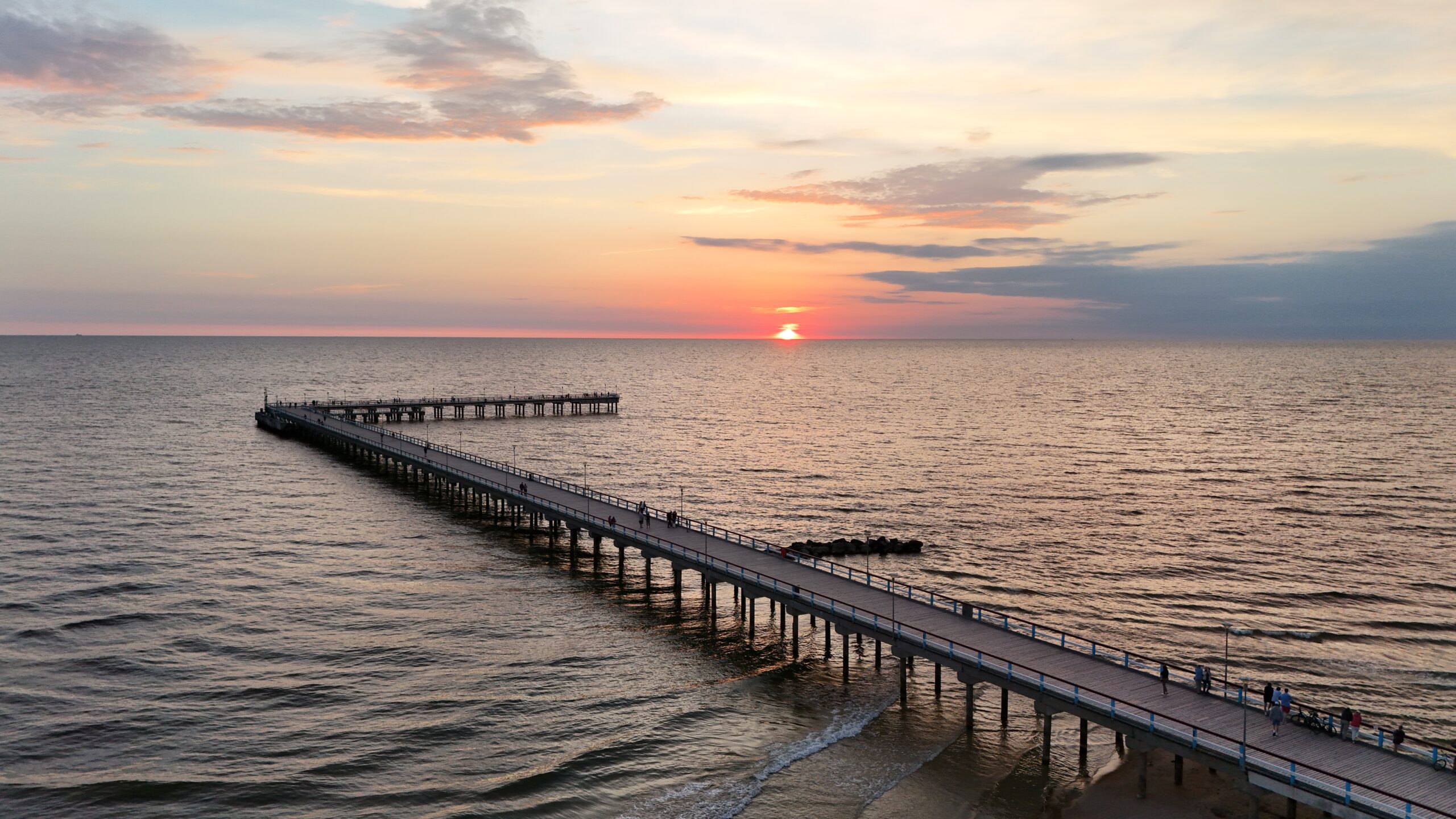 Pier extending over calm water at sunrise near Chic's Beach, Virginia Beach